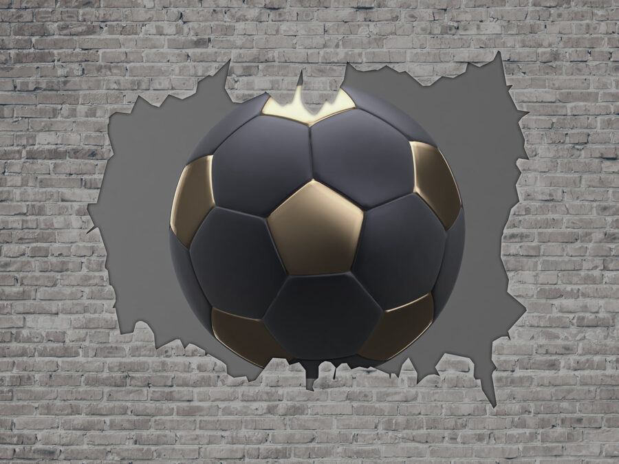 Un ballon de football traverse un mur Un ballon de football traverse un mur