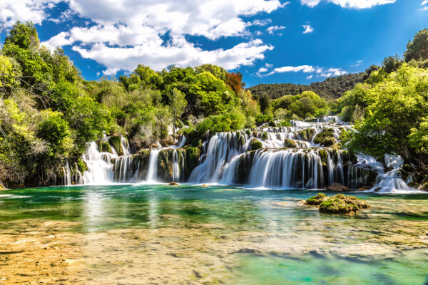 Le parc national de Krka entouré d'arbres et d'un ciel bleu Le parc national de Krka entouré d'arbres et d'un ciel bleu