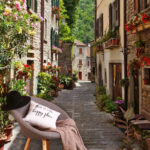 Papier peint Rue étroite avec des fleurs et des plantes sur le côté