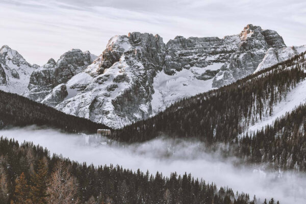 Chaîne de montagnes enneigées avec des arbres et un bâtiment Chaîne de montagnes enneigées avec des arbres et un bâtiment