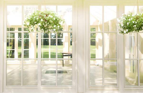 Porte-fenêtre blanche avec des fenêtres en verre et une plante en pot. Porte-fenêtre blanche avec des fenêtres en verre et une plante en pot.