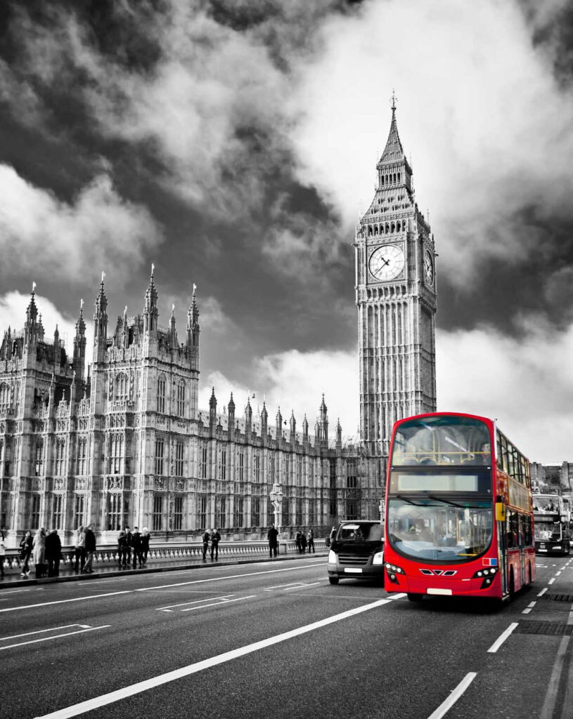 Bus rouge à impériale dans une rue avec une tour d'horloge en arrière-plan Bus rouge à impériale dans une rue avec une tour d'horloge en arrière-plan