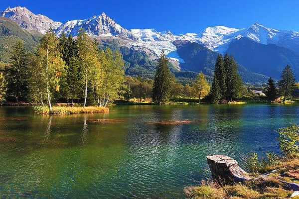 Un lac entouré d'arbres et de montagnes Un lac entouré d'arbres et de montagnes