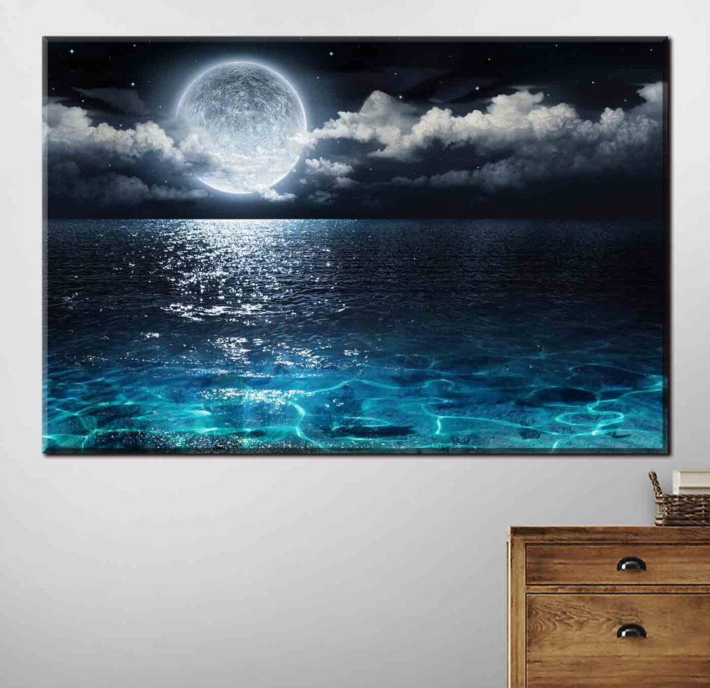 A moon over water at night