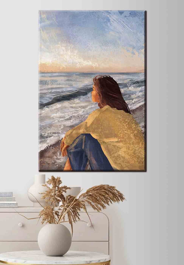 A woman sitting on a beach looking out to the ocean