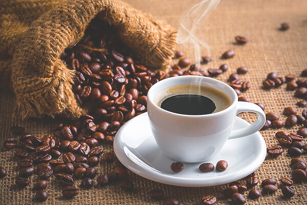 A cup of coffee and a bag of coffee beans A cup of coffee and a bag of coffee beans