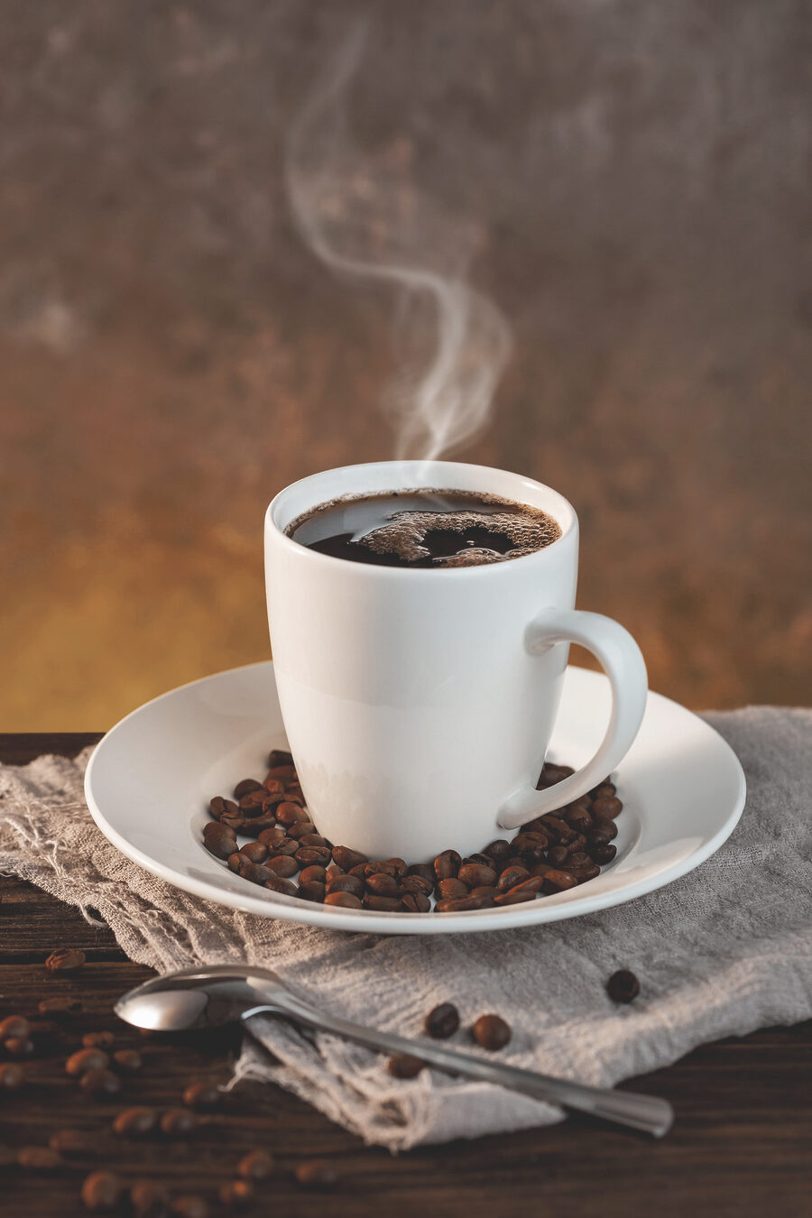 Une tasse de café sur une assiette avec des haricots et une cuillère