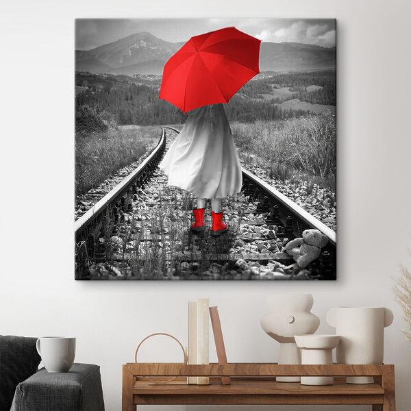 A person with a red umbrella on a train track A person with a red umbrella on a train track