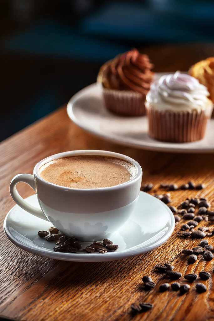 Cup of coffee and cupcakes on a table