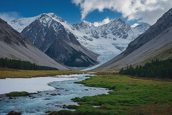 Rivière traversant une vallée avec des montagnes enneigées Rivière traversant une vallée avec des montagnes enneigées