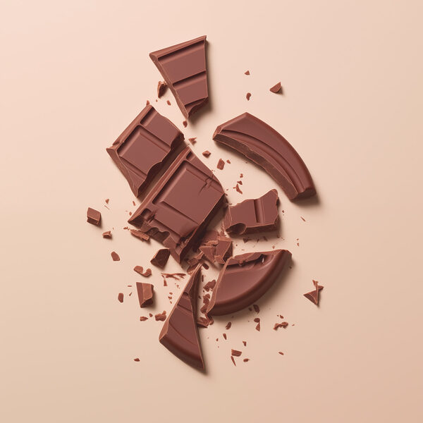 Barre de chocolat cassée sur une surface rose Barre de chocolat cassée sur une surface rose