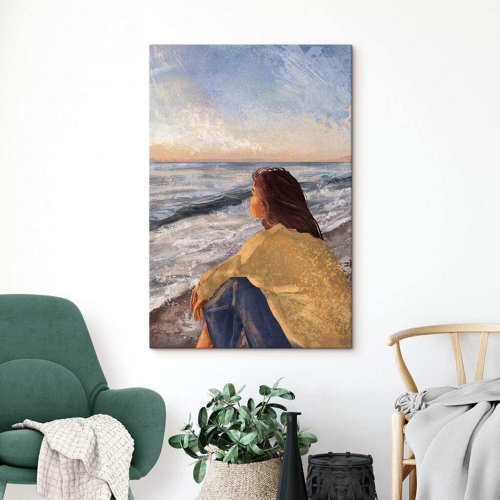A woman sitting on a beach looking out to the ocean
