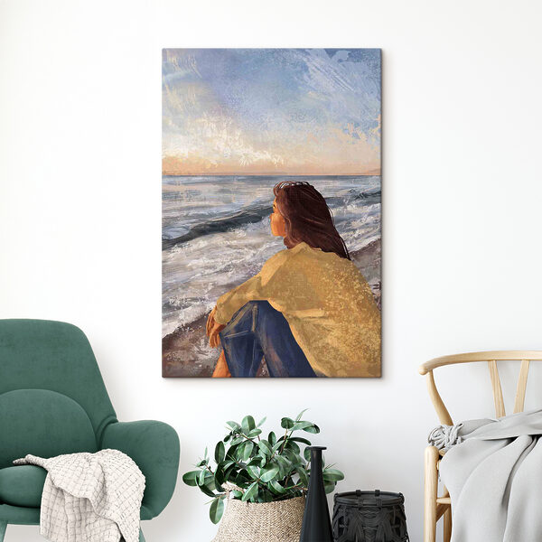 Une femme assise sur une plage regardant l'océan Une femme assise sur une plage regardant l'océan