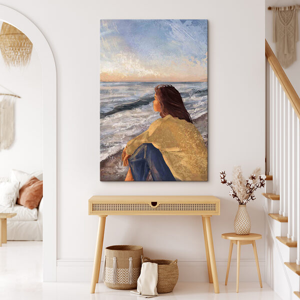 Une femme assise sur une plage regardant l'océan Une femme assise sur une plage regardant l'océan