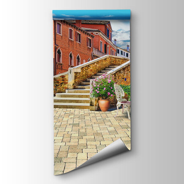 Patio with a table and chairs and a fountain in front of a building